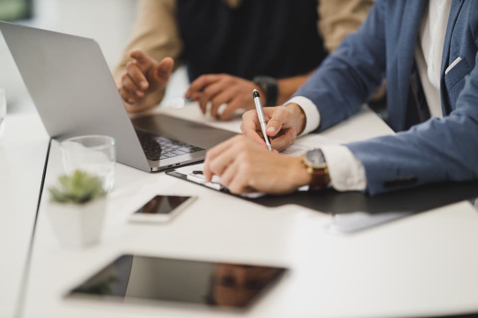 Colleagues working together on laptops around a meeting table